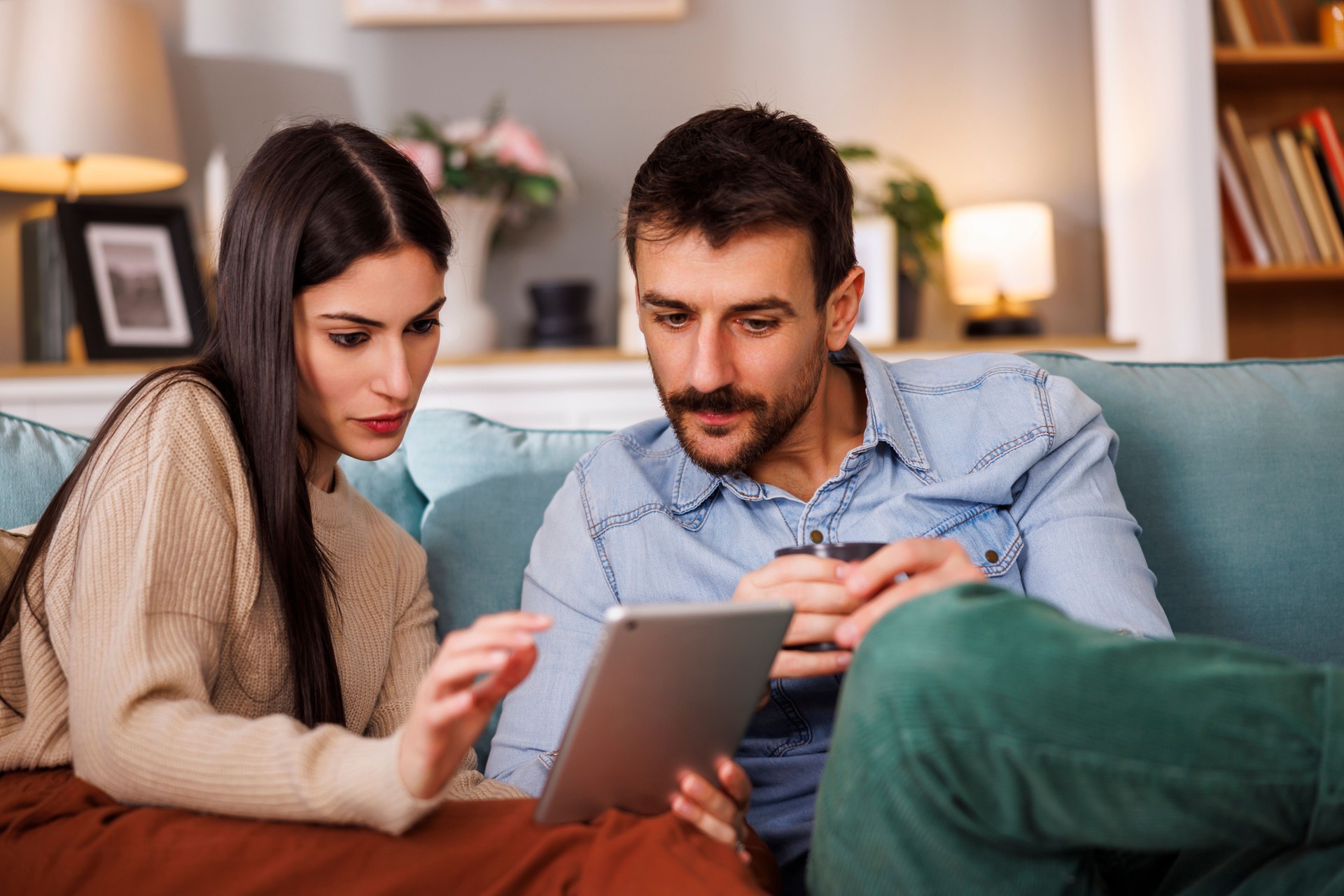 Couple paying bills and taxes online using tablet computer at home