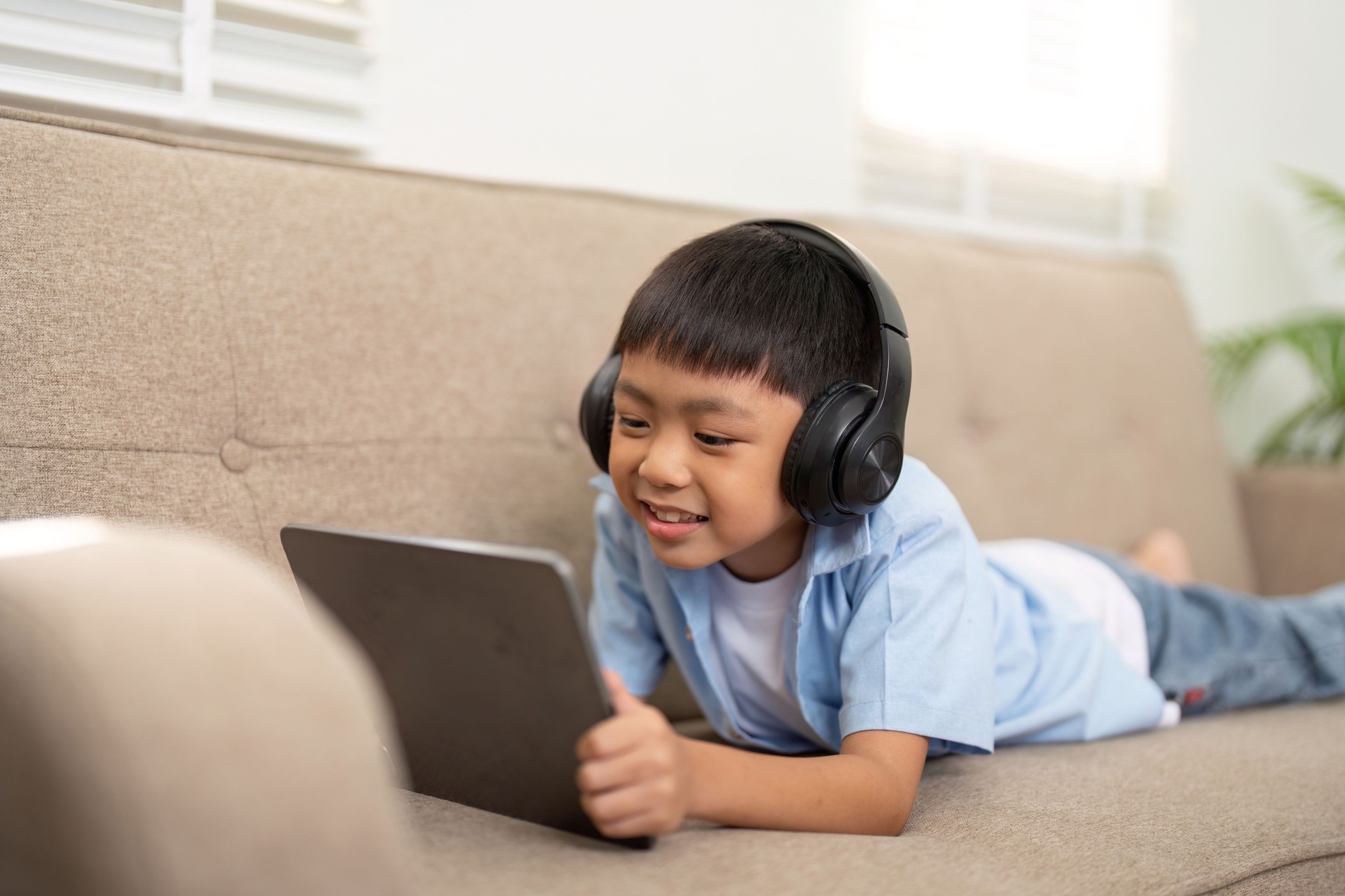 Back to School. Young boy using tablet for learning at home.